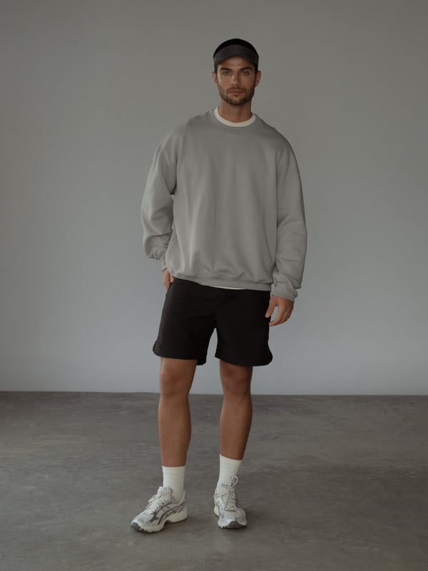 Modelo usando buzo color gris y pantaloneta color negro con medias largas