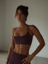 Vista frontal modelo con top deportivo de tiras vino y short.