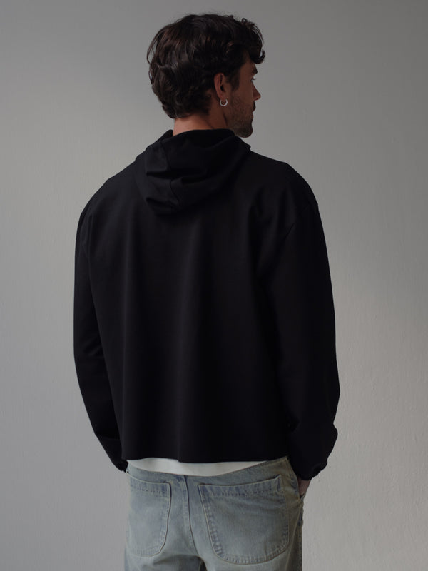 Vista posterior de buzo negro con capucha para hombre.