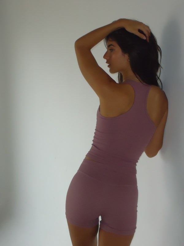 Vista posterior modelo con tank y mini short rosado sin costuras.