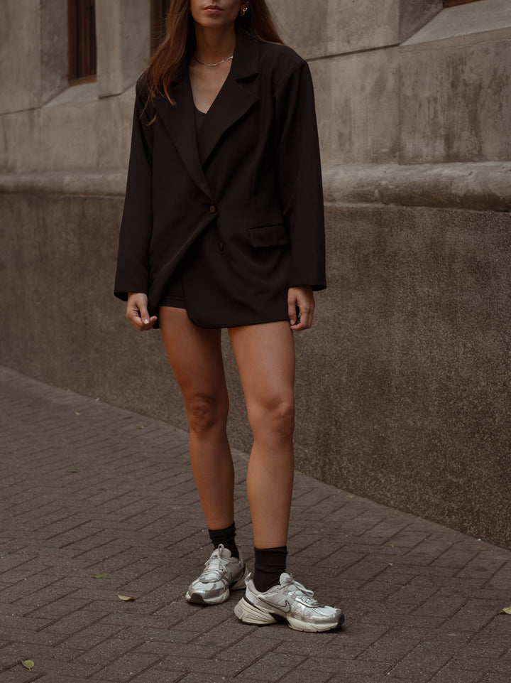 Blazer color negro en silueta oversized, con bolsillos laterales, forro interior y botones frontales