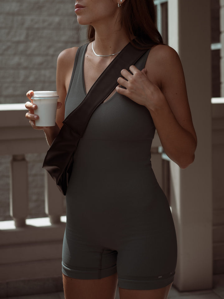 Modelo usando un  enterizo color gris con un bolso color café