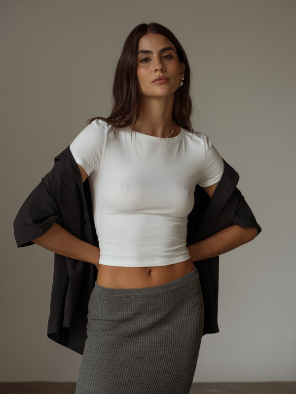 Vista frontal falda larga, crop top y camisa corta
