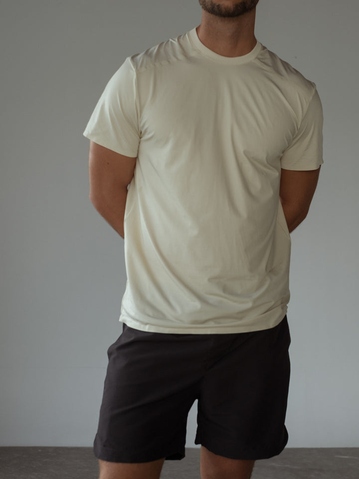 Camiseta color crema manga corta, pantaloneta azul oscuro.