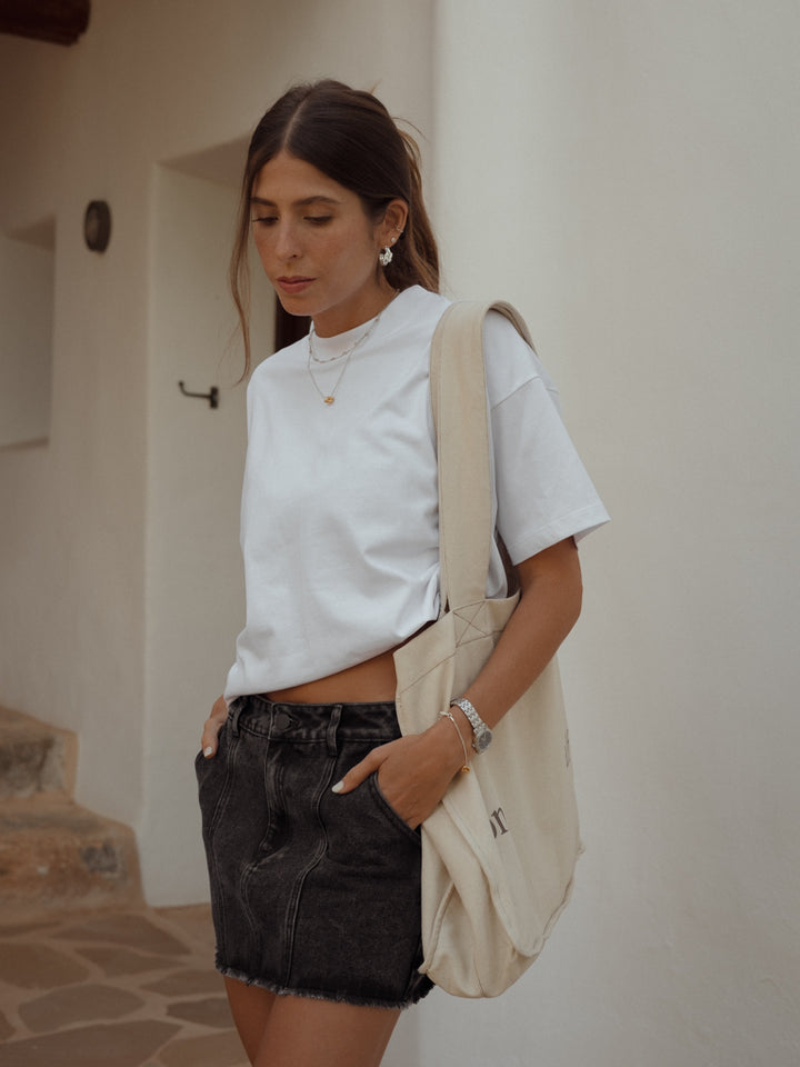 Bolso con "one half" estampado, falda denim negra y camiseta ancha