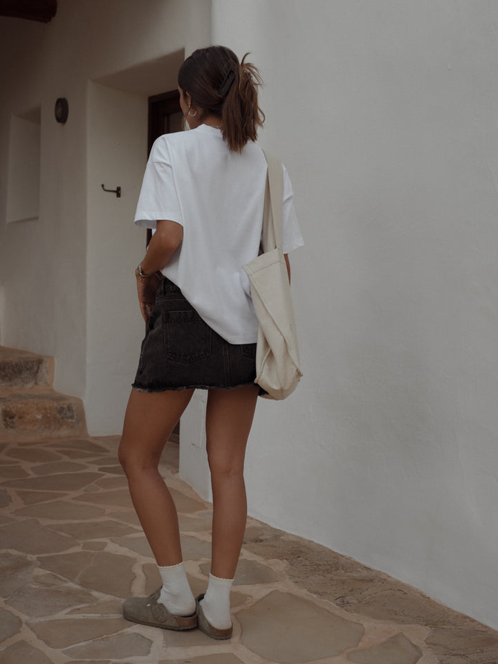 Vista posterior falda con bolsillos denim, medias largas y camiseta básica 