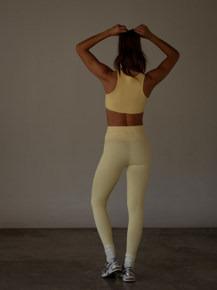 Vista posterior del crop top y el leggings color amarillo