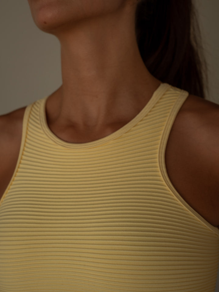 Vista detallada del cuello del crop top color amarillo manga sisa
