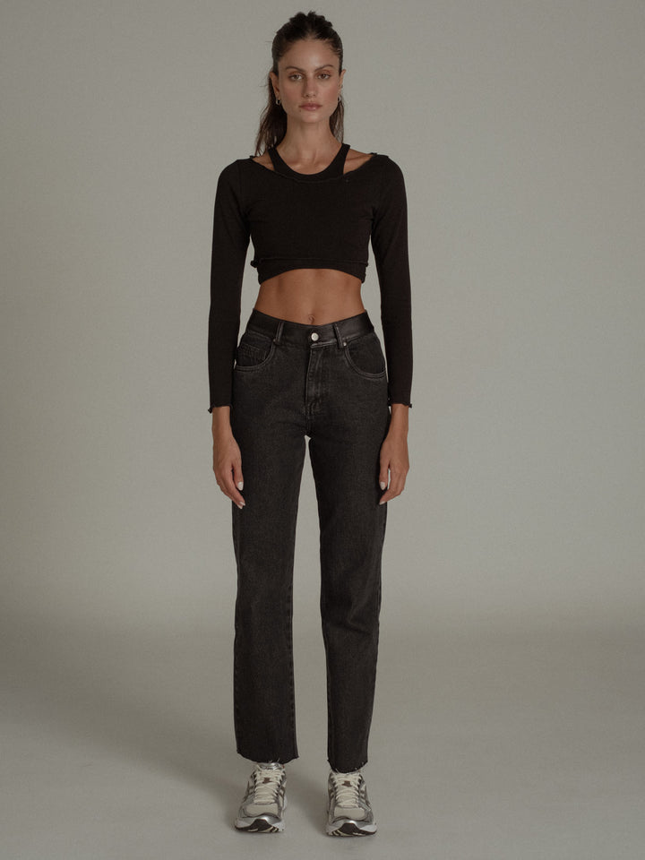 Vista completa frontal de la modelo usando un crop top manga larga negro con un jean