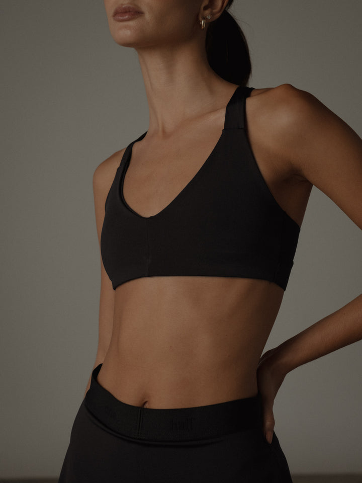   Crop top color negro con forro interior, escote frontal en "V" y espalda cruzada