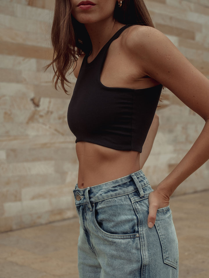 Vista lateral del crop top color negro con apariencia lisa 