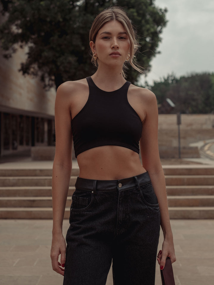 Vista frontal del crop top color negro con apariencia lisa 