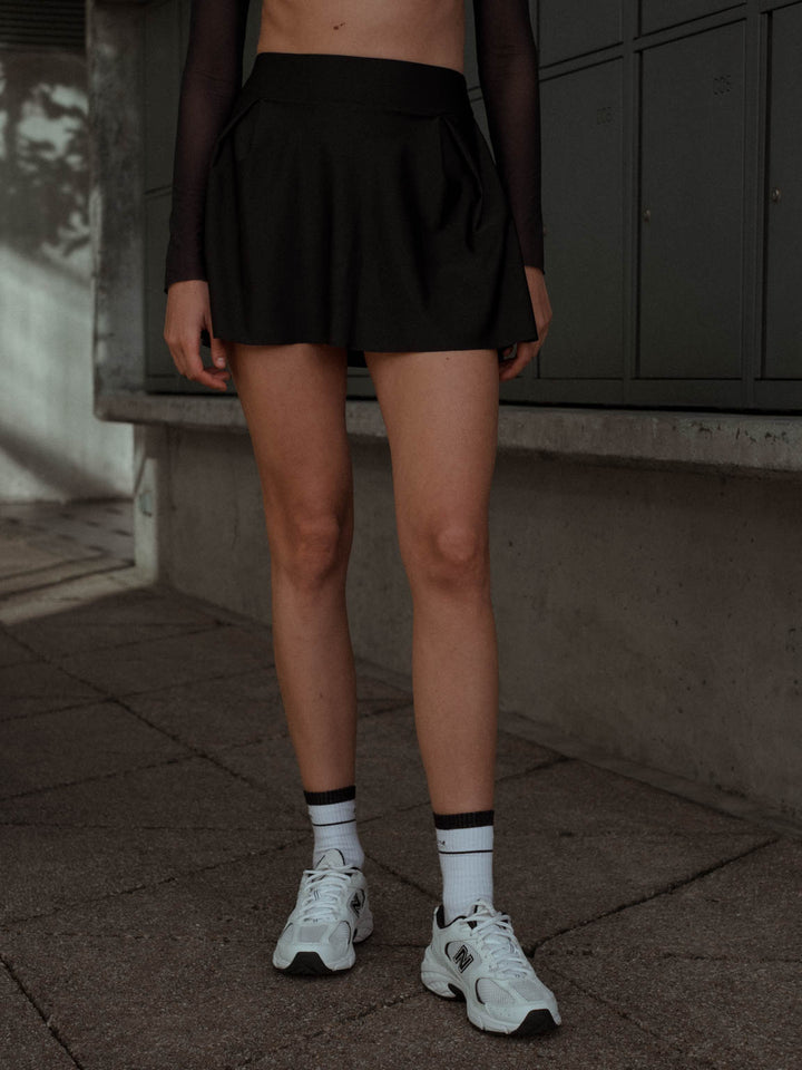 Vista frontal de falda deportiva con pliegues color negro