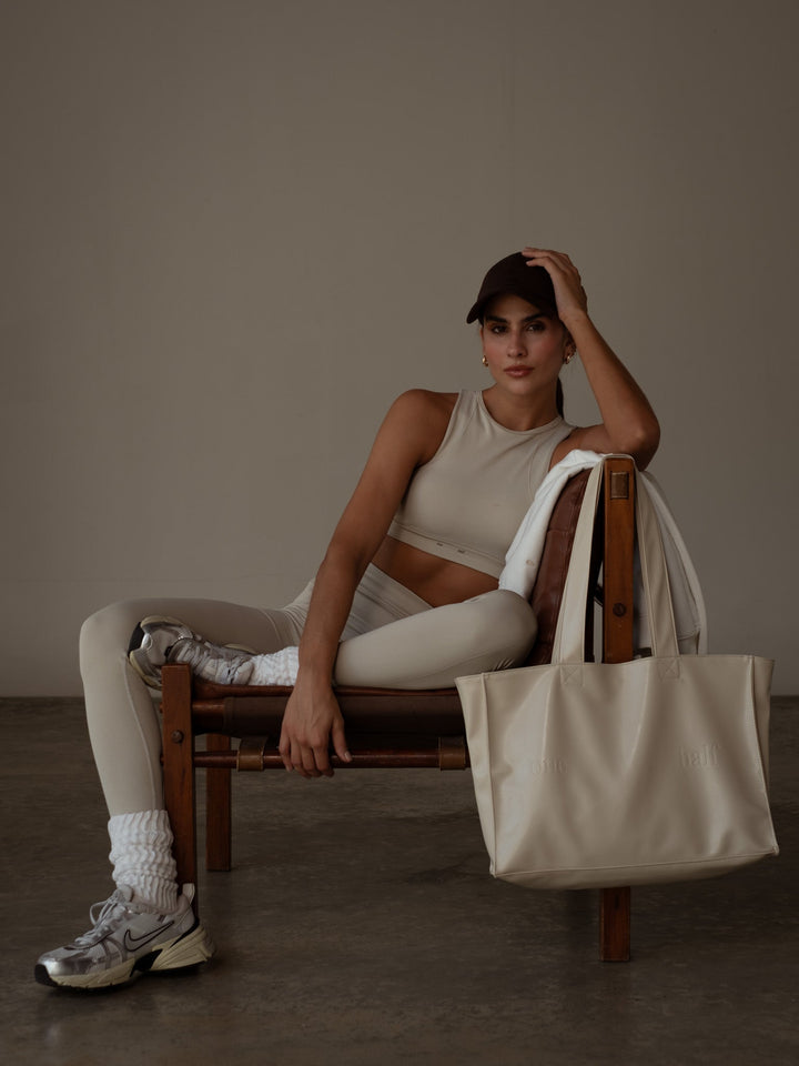 Modelo usando un conjunto deportivo y una gorra clásica color café