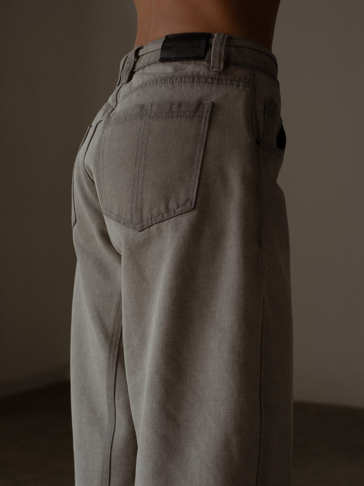 Vista detallada de los bolsillos posteriores del jean color gris
