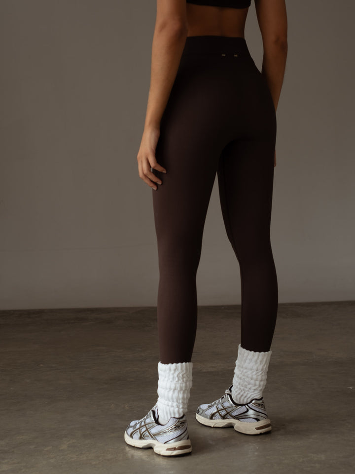 Vista posterior del leggings deportivo color café con pretina acanalada doble