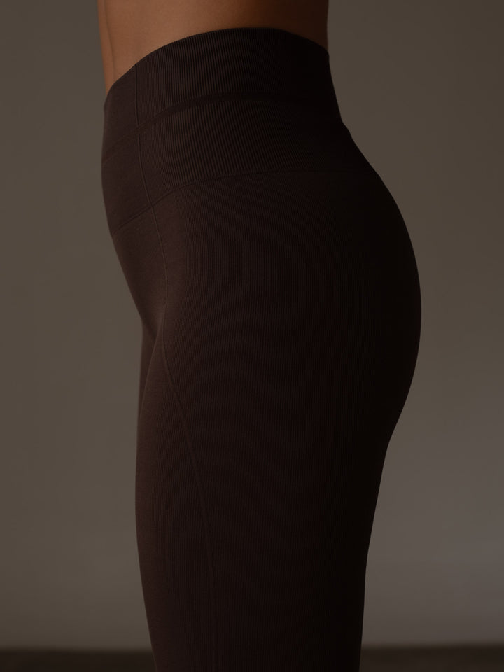 Vista detallada lateral de la parte de la pretina acanalada doble y compresión en el abdomen del leggings color café