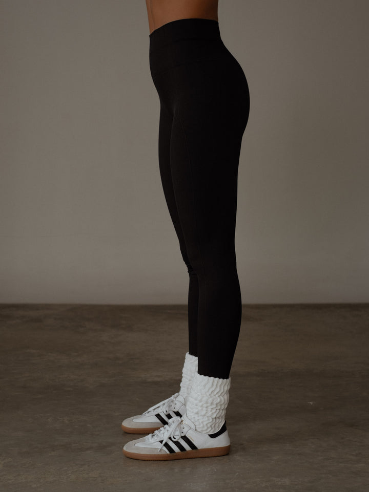 Vista lateral del leggings deportivo color negro para mujer