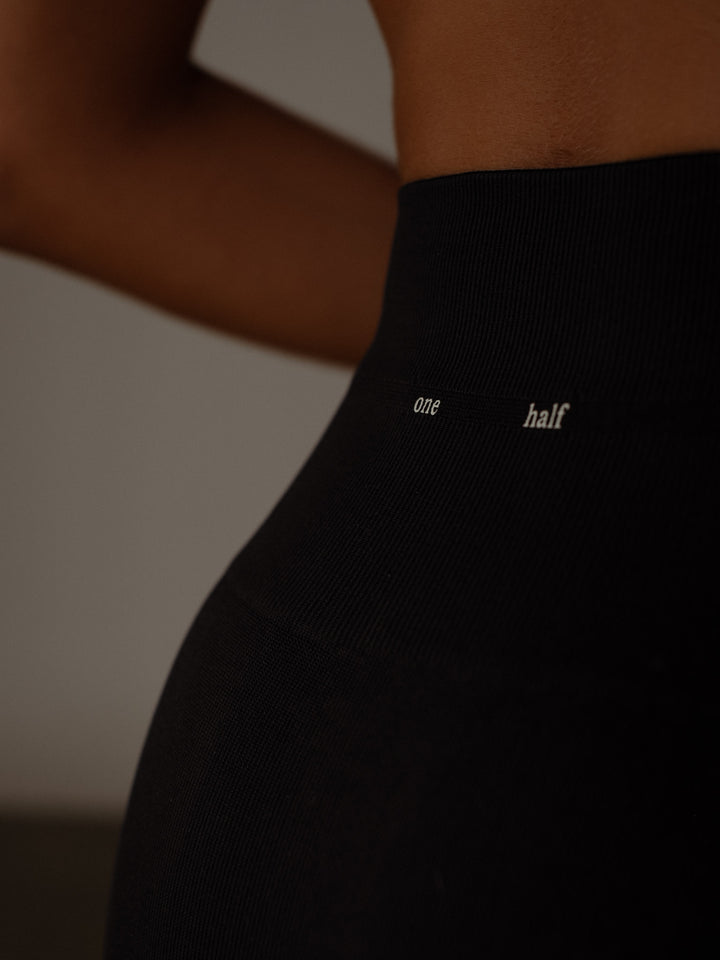 Vista detallada de la parte posterior en la pretina del leggings con letras "One Half"