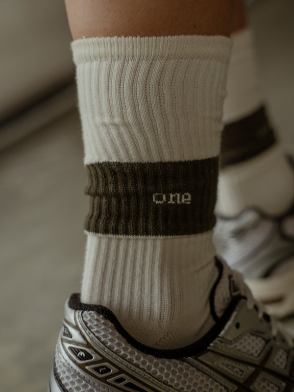 Palabra "One" bordado en color crudo medias largas color crudo y verde.