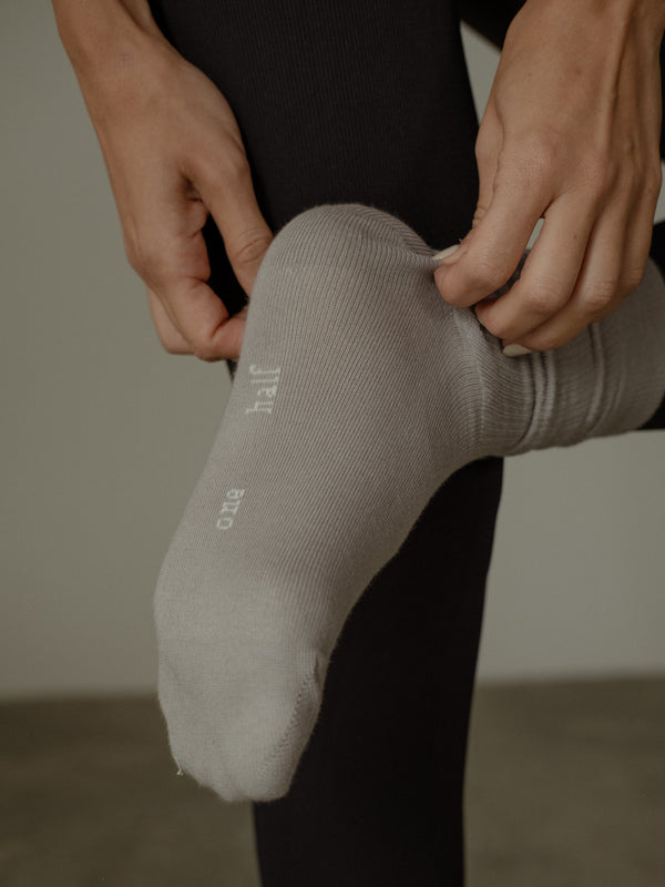 "One half" bordado en la parte posterior de la media en color crudo.