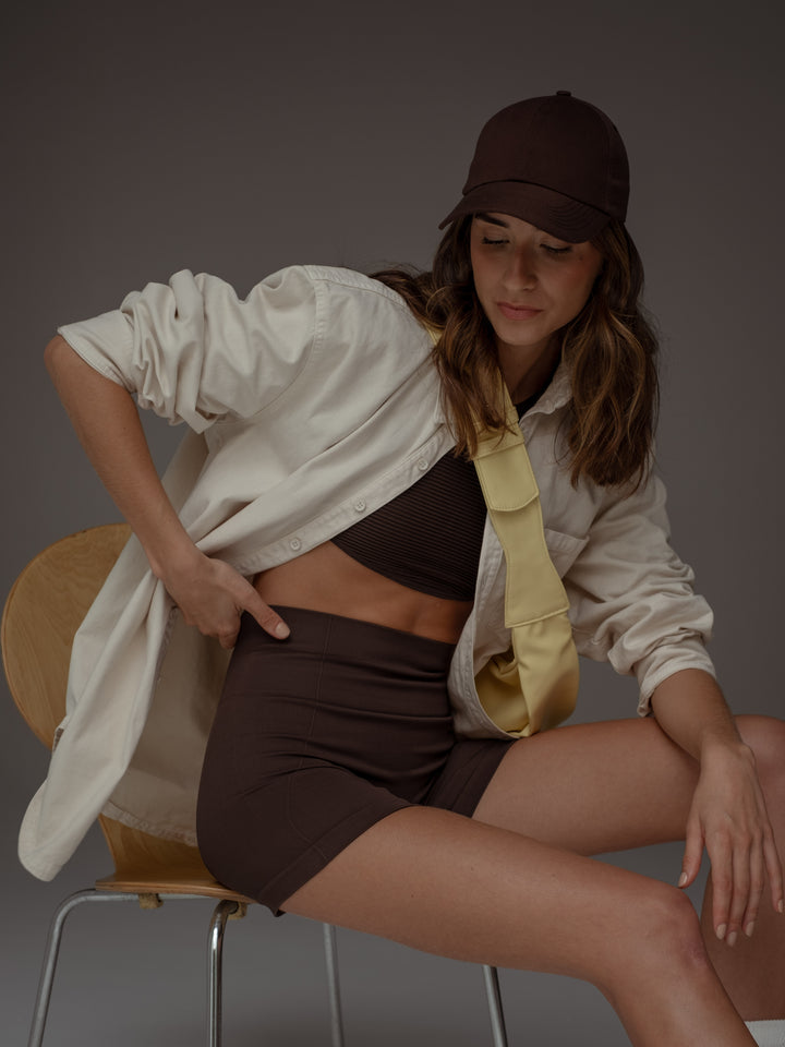 Modelo usando un conjunto color café, una gorra color café y una chaqueta