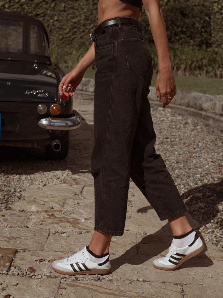 Vista lateral del jean bota recta con lavado negro vintage
