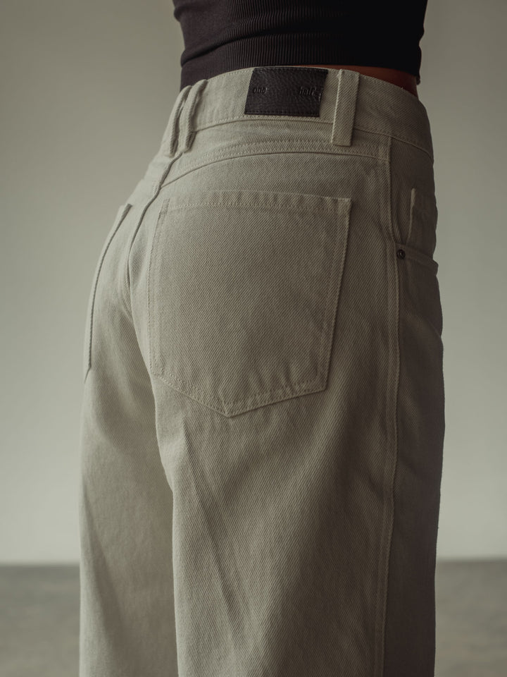 Vista detallada del bolsillo posterior del jean color taupé