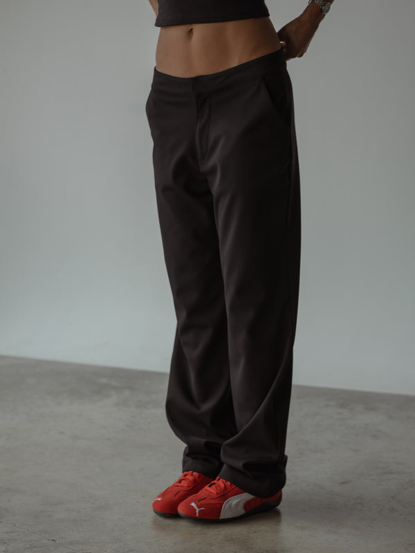 Plano medio de modelo usando un pantalón clásico color negro de tiro medio y bota recta.