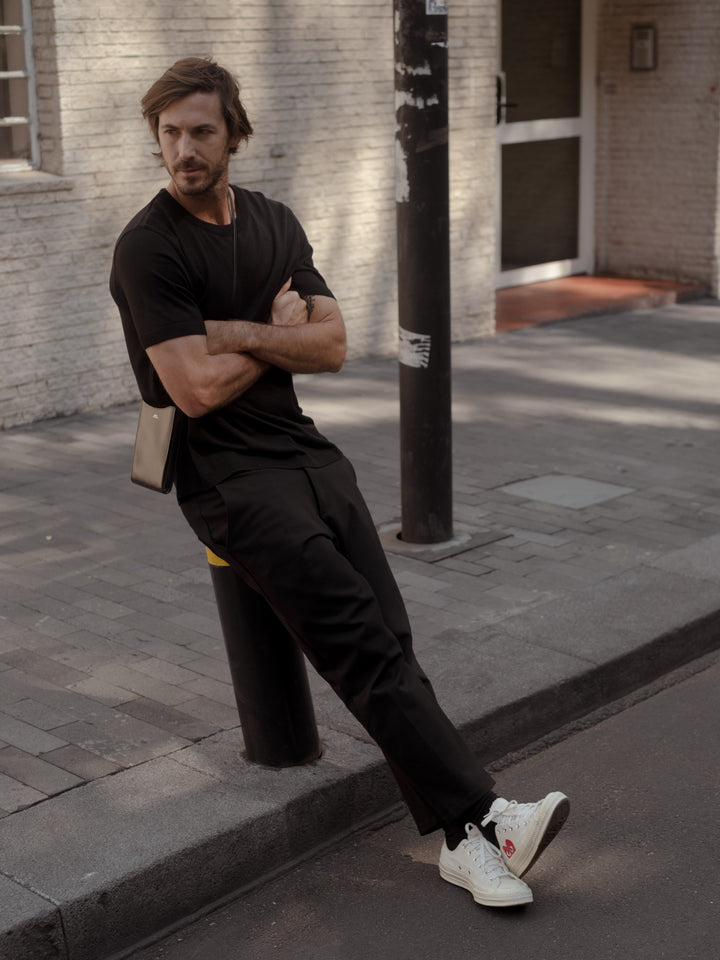 Modelo usando un pantalón tobillero y una camiseta color negro.