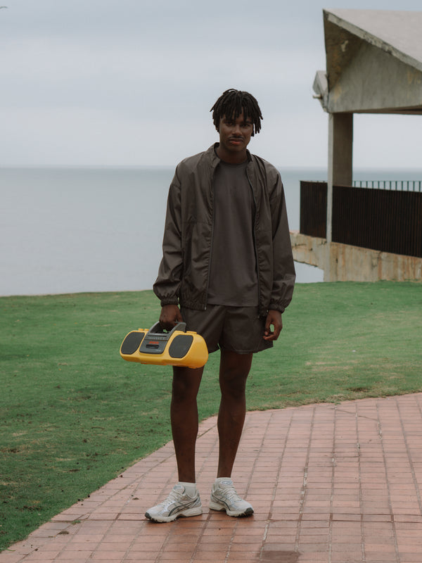 El modelo esta usando un set deportivo y una chaqueta color gris