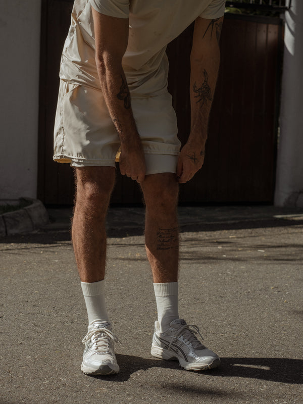 Modelo usando pantaloneta con short interno de apariencia lisa color gris.