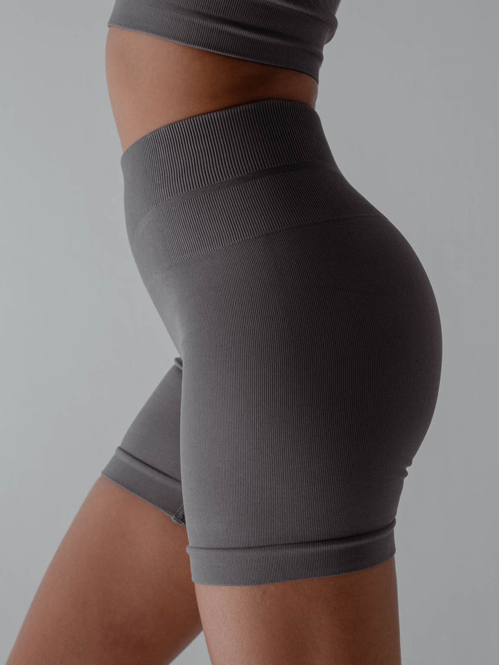 Vista lateral de la modelo usando short color gris para mujer.