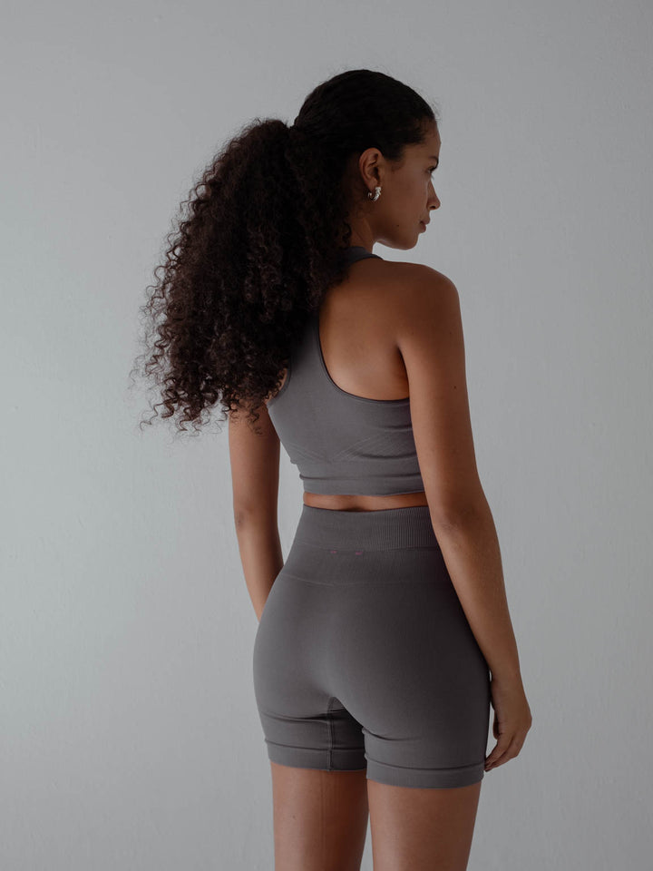 Vista posterior de la modelo usando top y short color gris para mujer.