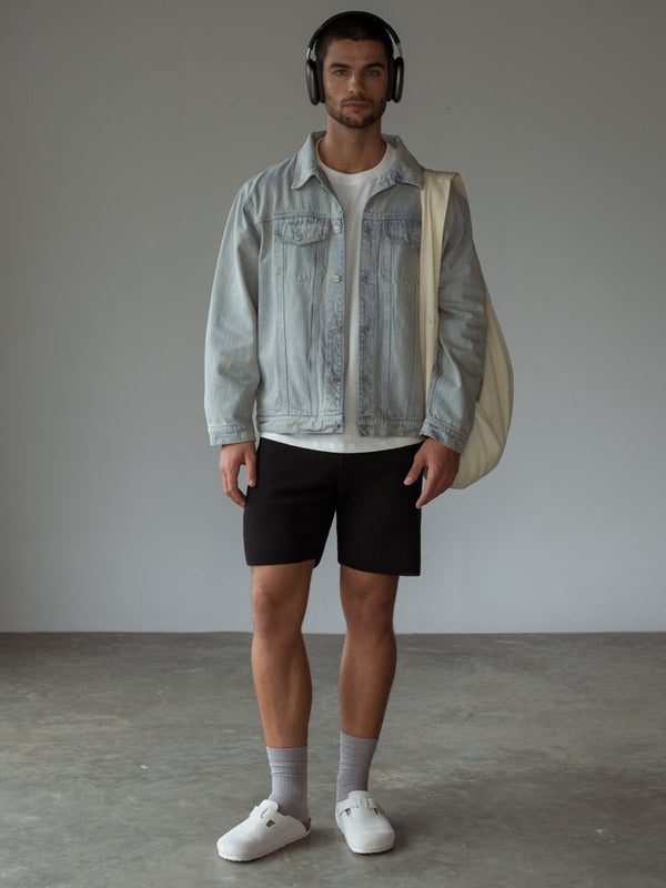 Chaqueta denim, camiseta básica color crudo, short negro, medias grises.