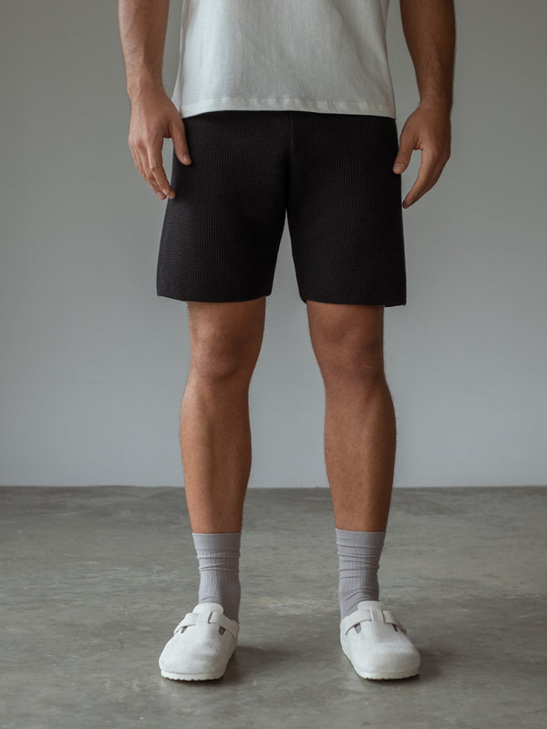 Short tejido, camiseta básica color crudo y medias largas.