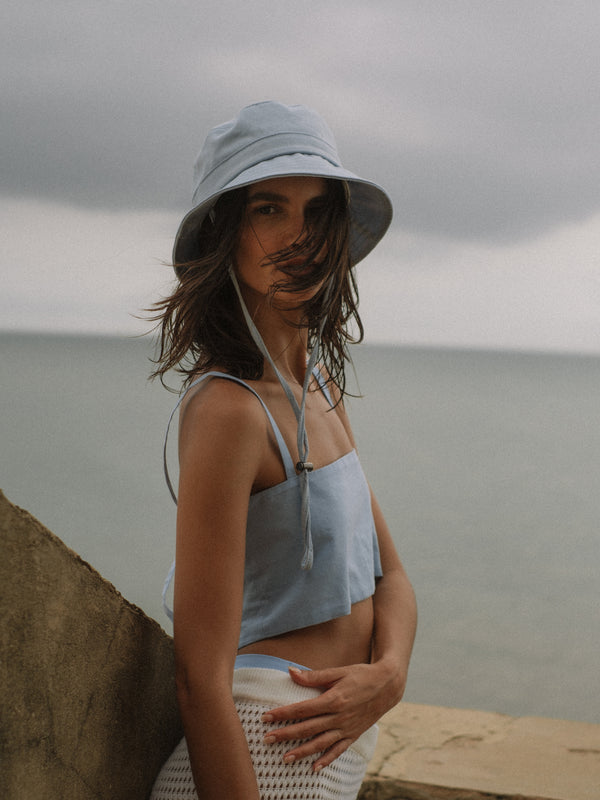 Vista diagonal gorra y crop top corto azul claro