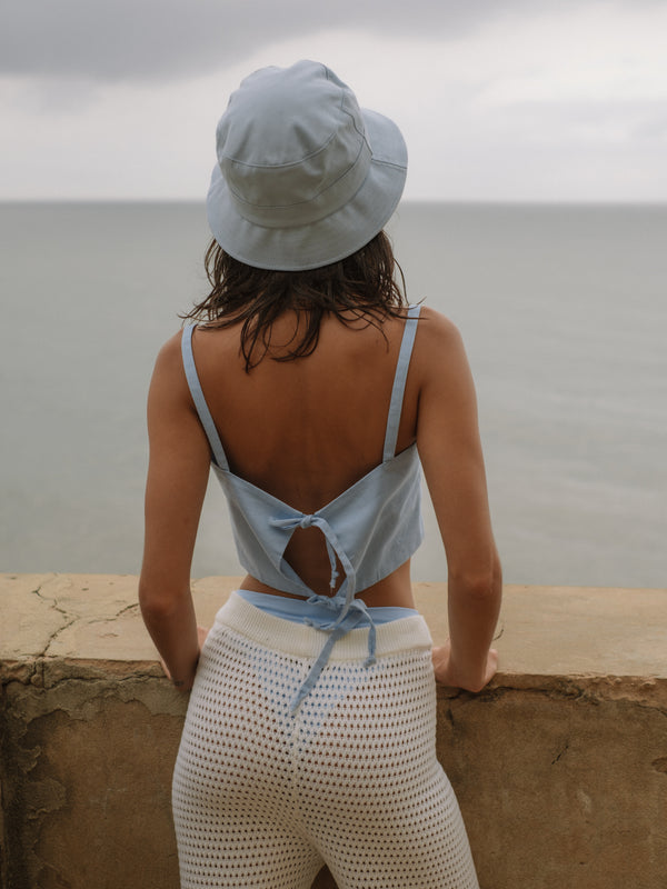 Vista posterior crop top con amarre y tiras, pantalón transparente color crema