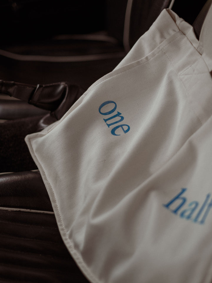 Vista detallada del estampado azul "One Half" en el bolso color crudo