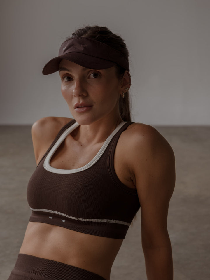 Visera deportiva color café con crop top deportivo.