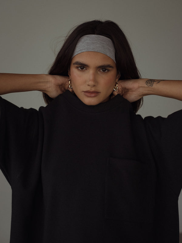 Vista frontal de la modelo usando camiseta negra manga corta y banda para el cabello gris