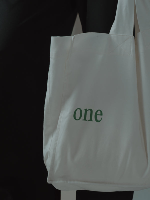 Vista a detalle de tote bag crudo con verde.