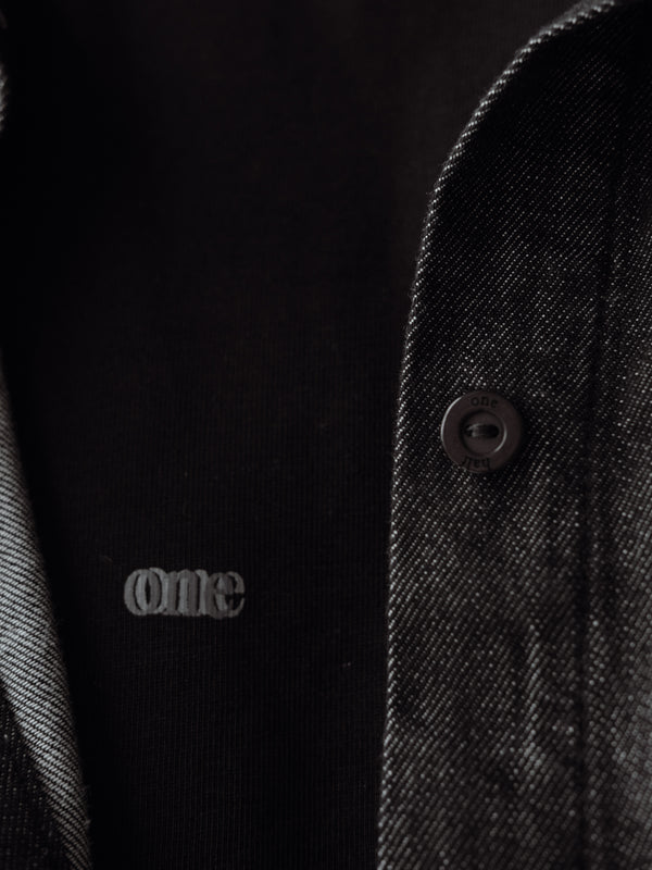 Vista a detalle de botones de la camisa negra manga larga.