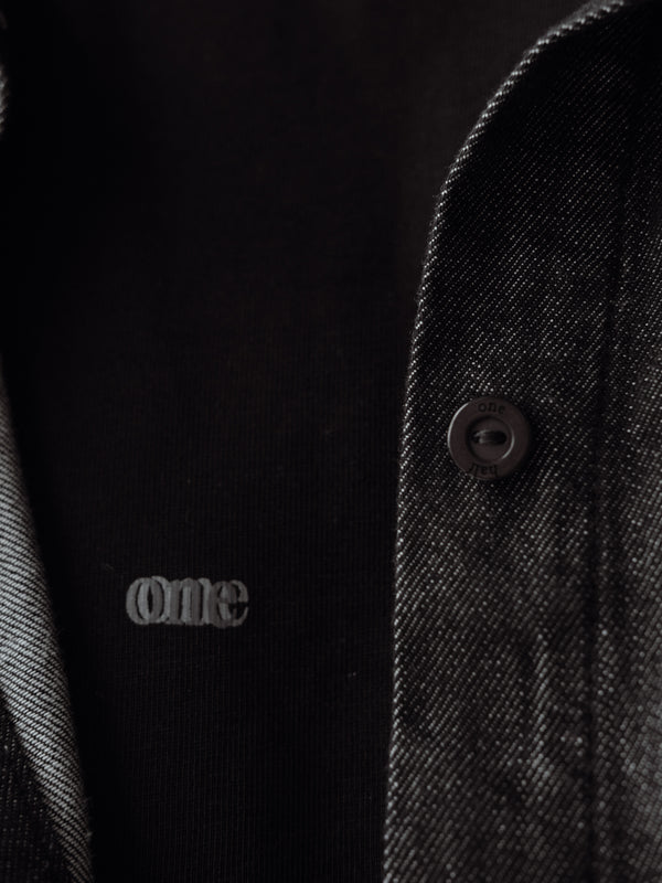 Vista a detalle de botones de la camisa negra manga larga.