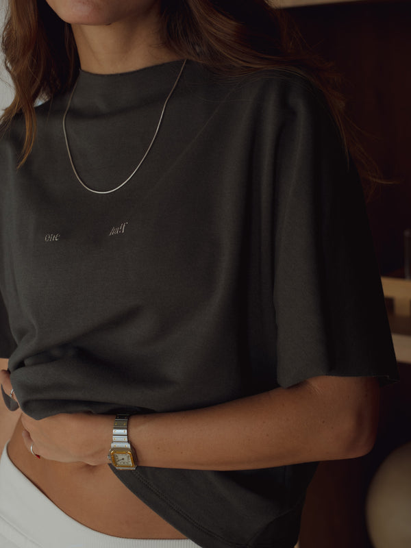 Vista a detalle de camiseta gris para mujer con cuello y mangas al corte.