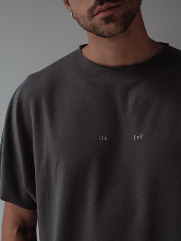 Vista frontal camiseta gris con estampado "one Half" , cuello y mangas al corte.