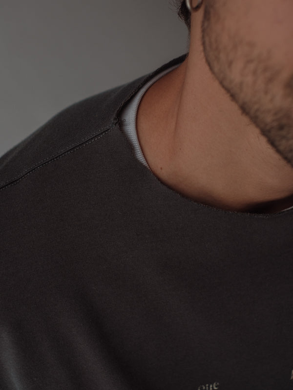 Vista a detalle cuello al corte de camiseta gris oversized. 