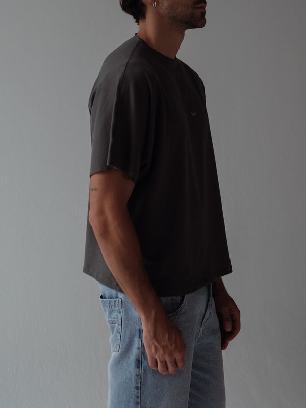 Vista lateral modelo usando camiseta gris con detalles al corte.