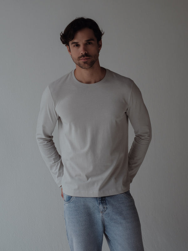 Modelo usando camiseta manga larga cuello redondo color gris fit regular.