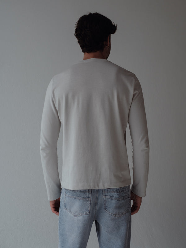 Vista posterior modelo usando camiseta manga larga gris claro. 